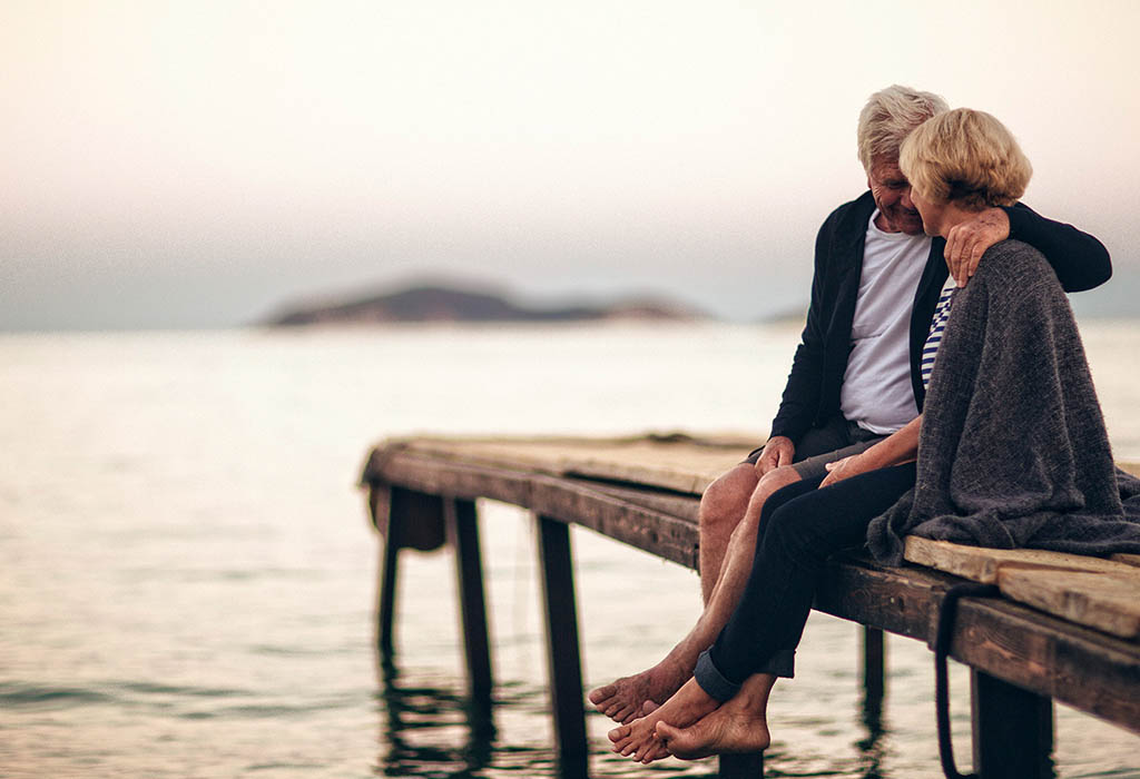 Older couple cuddling on wharf