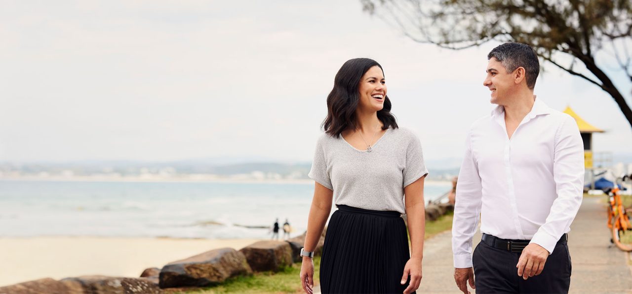 Lisa and Saul CHG Integrated Wealth walking by the beach