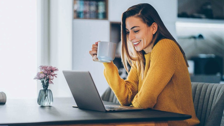 Woman smiling whole looking at laptop