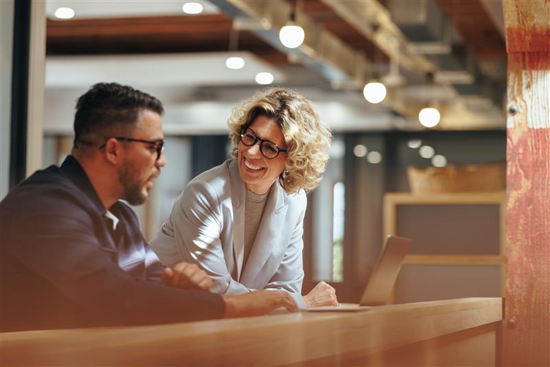 business woman and man talking at computer