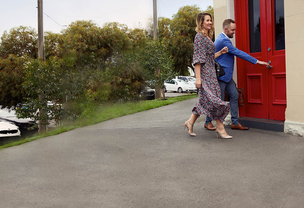 Business woman and business man outside opening an office door