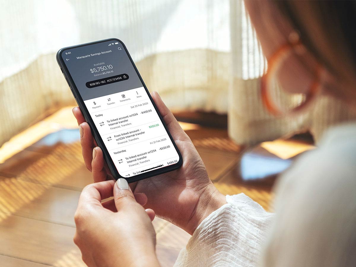 Woman holding phone with macquarie app