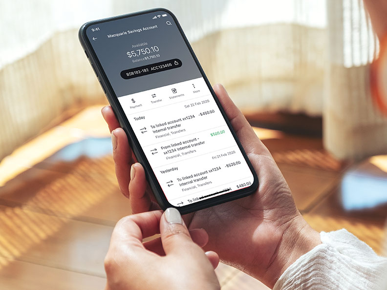 Woman holding phone and using the Macquarie app.