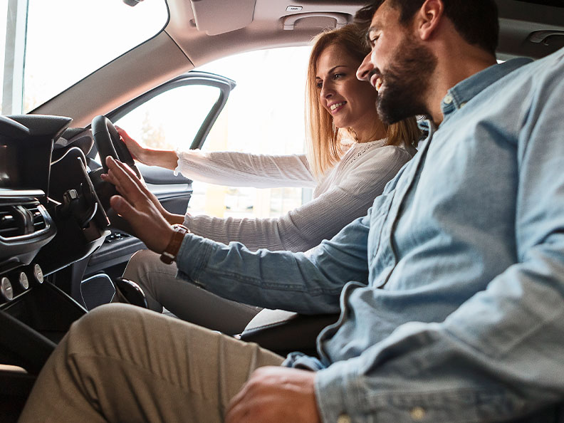 Couple checking inside new car