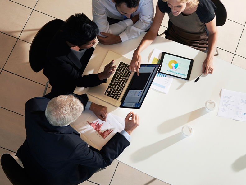 group-of-coworkers-in-discussion-around-laptop