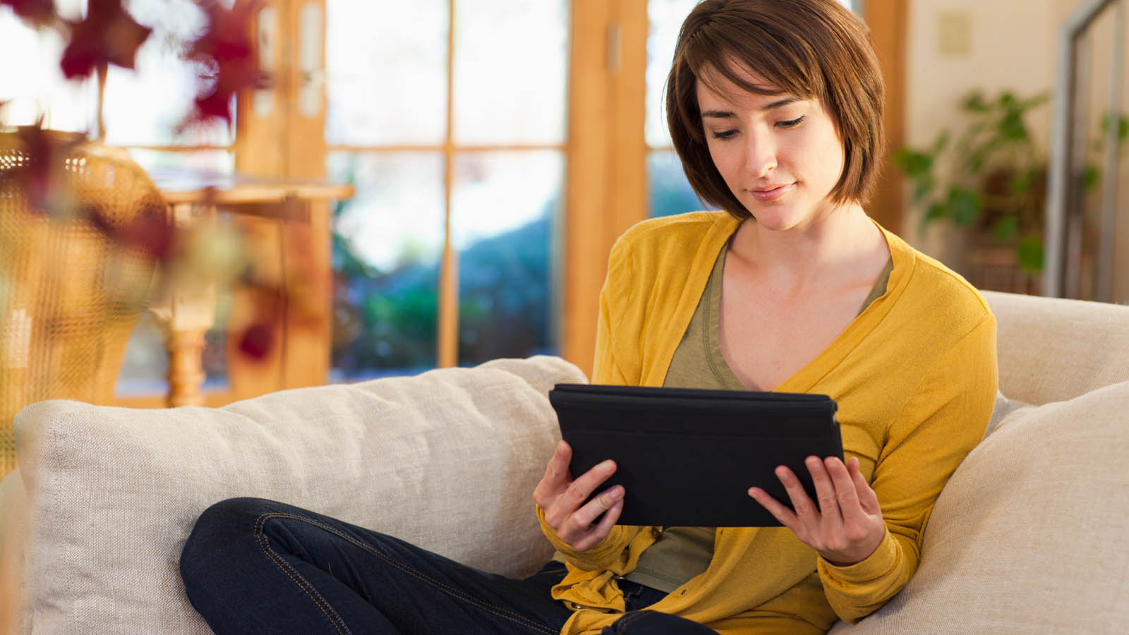 Woman yellow cardigan holding tablet
