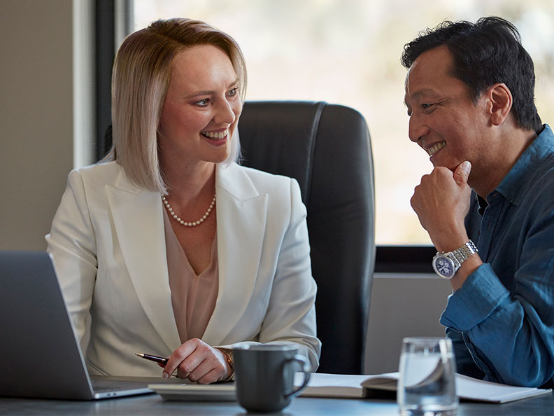 A business woman talks her client through something in an office meeting room. Macquarie - Deanna Chi