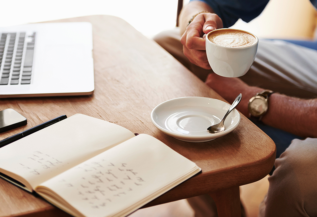 Cropped image of a young man working on his laptop in a coffee shop