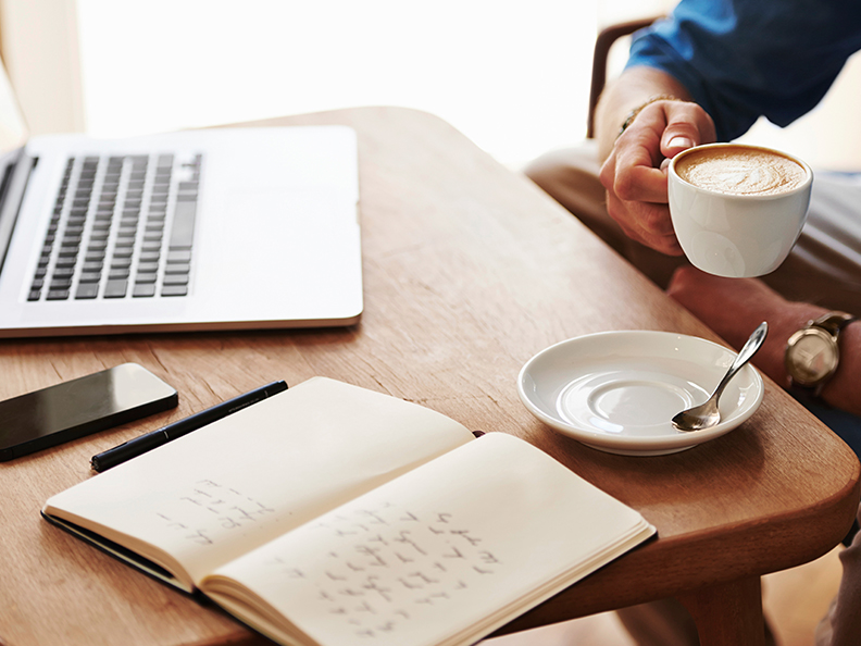 Cropped image of a young man working on his laptop in a coffee shop