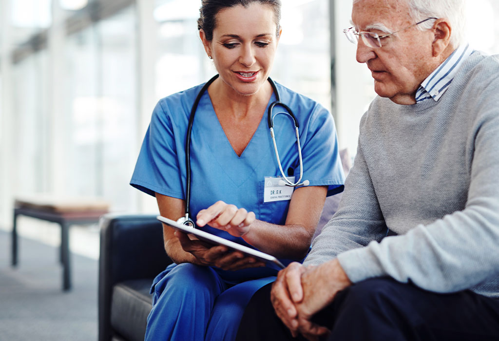 Female medical professional showing her elderly patient something on a digital tablet