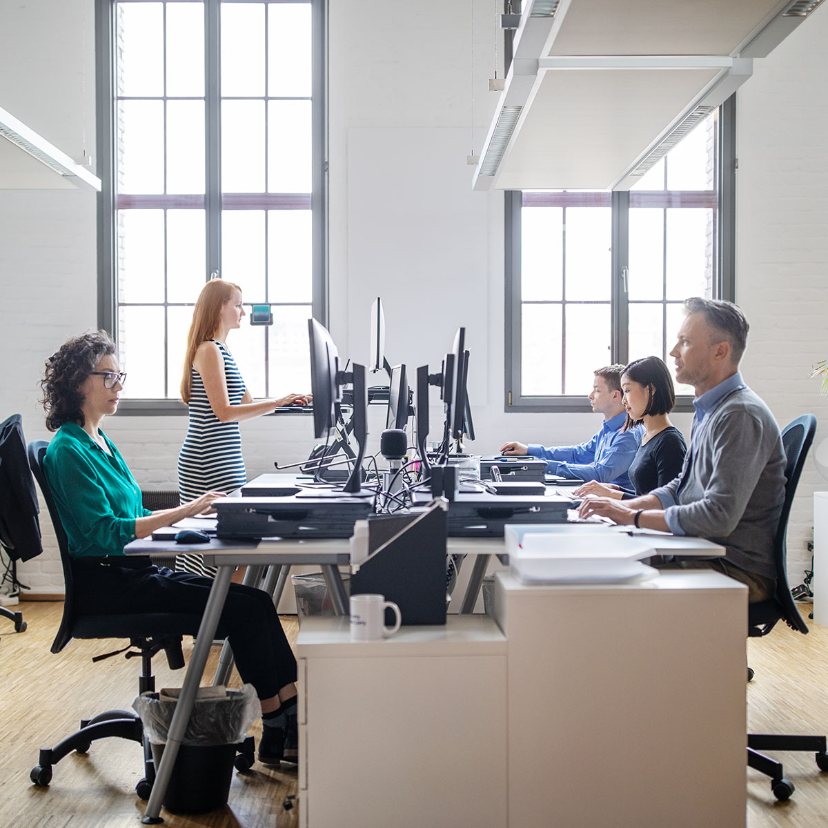 Business people at their desks in a busy, open plan office. Startup business people working at a modern office.