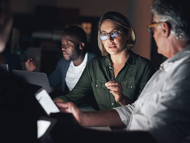 Shot of a group of colleagues having a meeting during a late night in a modern office