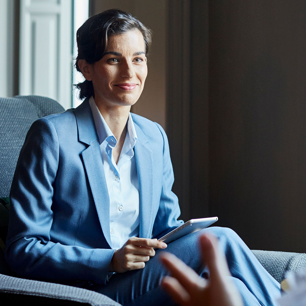 Lady sitting in chair wearing blue business suit