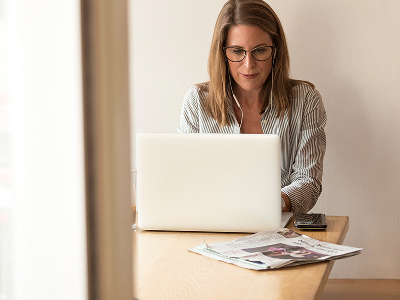 Middle aged lady with glasses on laptop