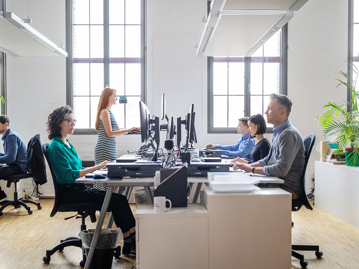 Business people at their desks in a busy, open plan office. Startup business people working at a modern office.