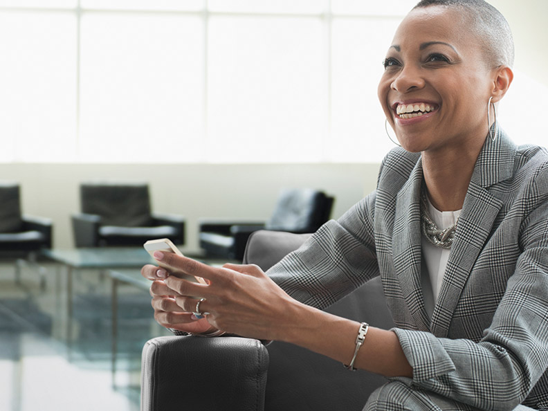 Women smiling in business suit holding phone
