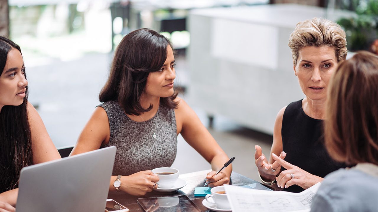 Group of professionals, mostly businesswomen, coming to snack bar or cafeteria for a coffee break. Businesswomen having an informal business meeting during the coffee break, but also having leisure time together.