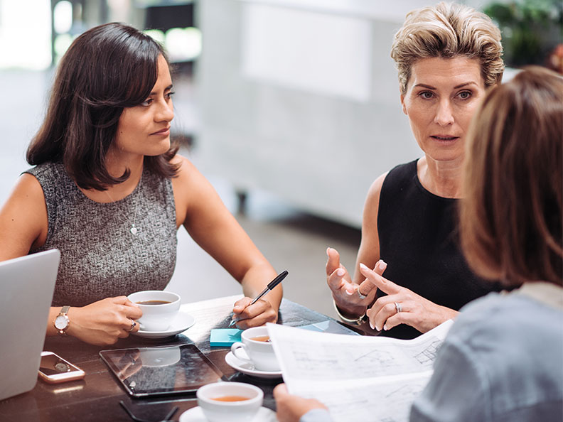 Group of professionals, mostly businesswomen, coming to snack bar or cafeteria for a coffee break. Businesswomen having an informal business meeting during the coffee break, but also having leisure time together.