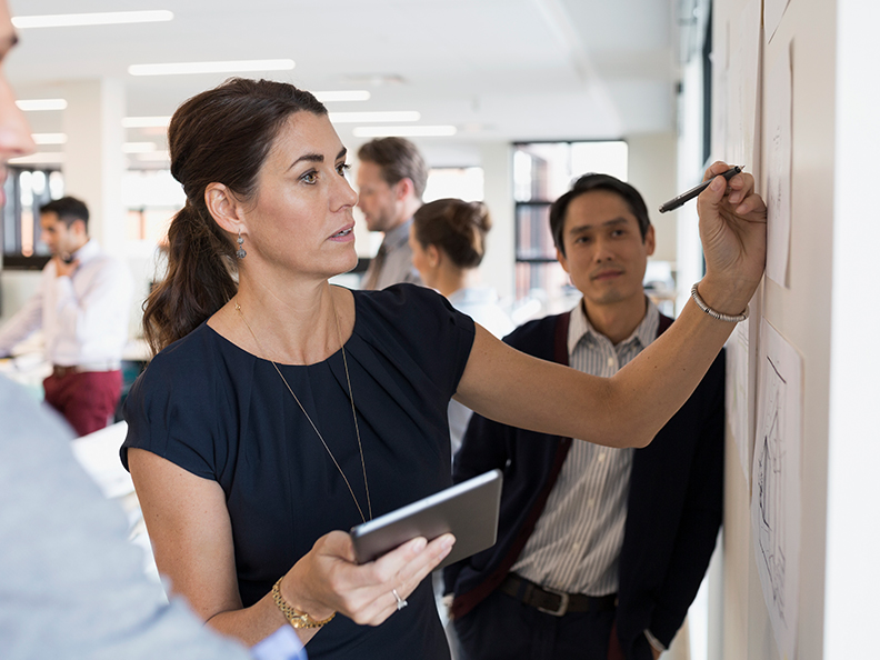 Businesswoman writing at wall