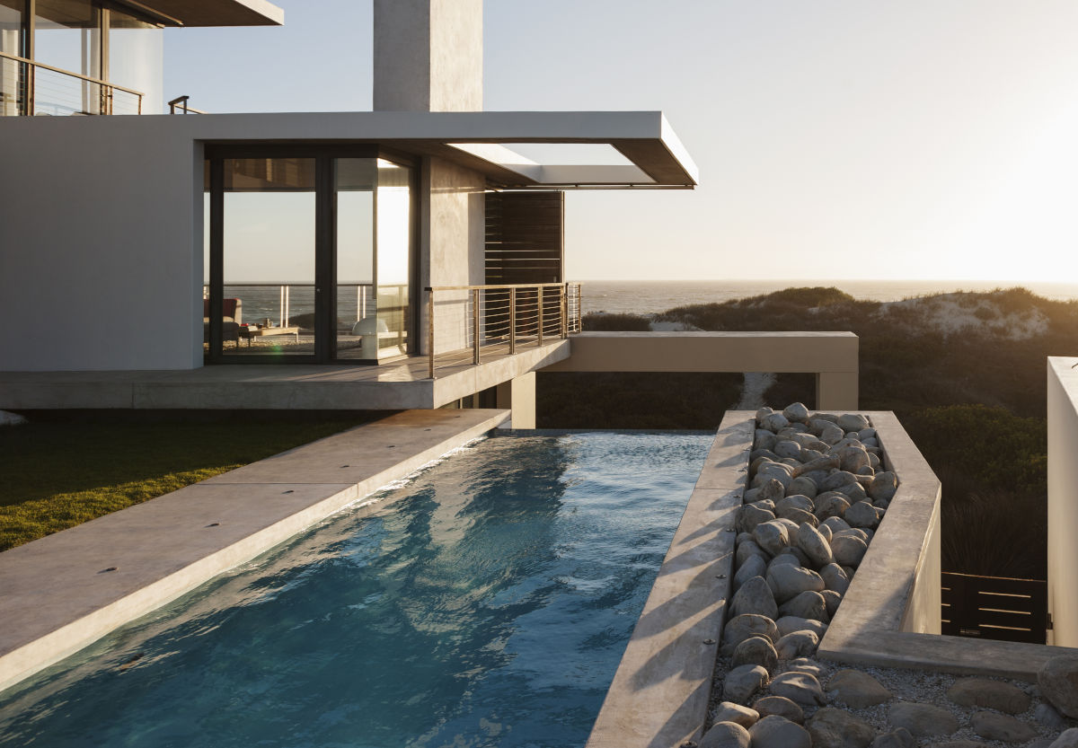 Modern house overlooking beach at sunset