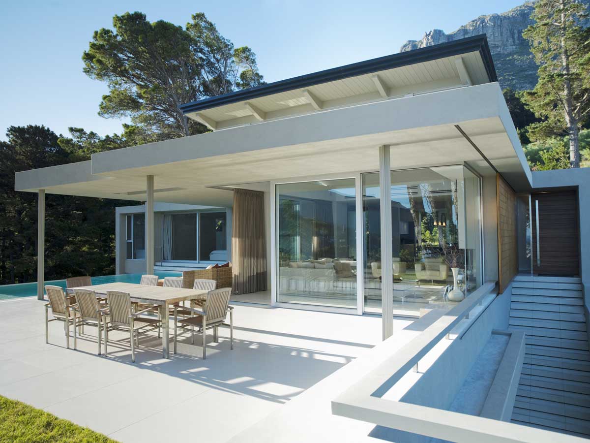 Outdoor shot of a modern house surrounded by mountains and trees
