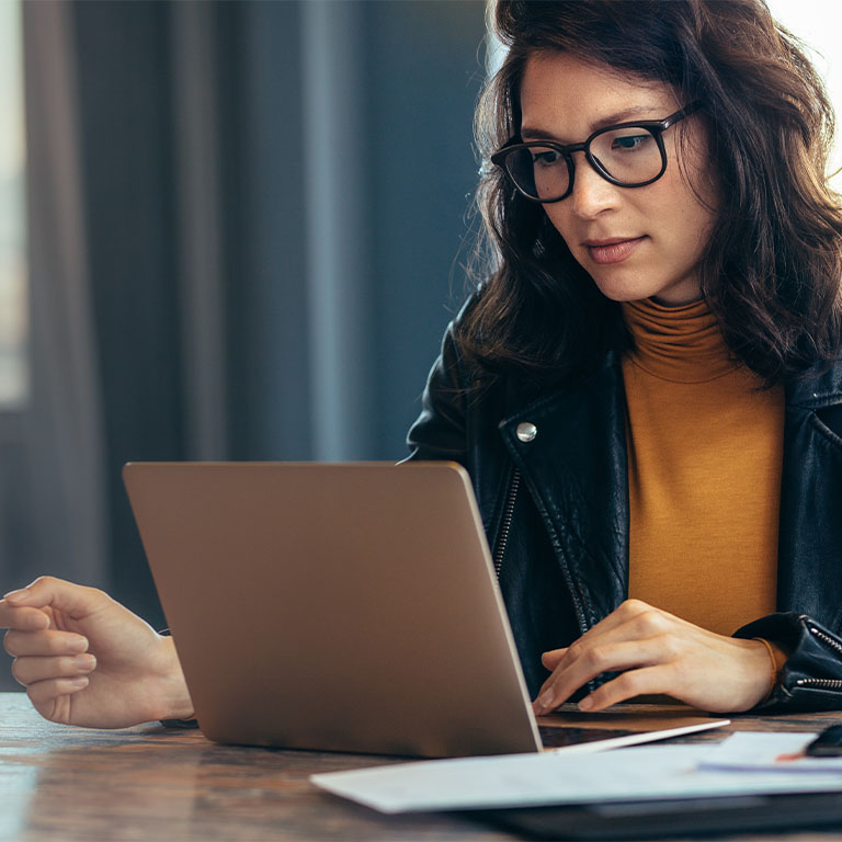Business woman busy working on laptop computer in open office.