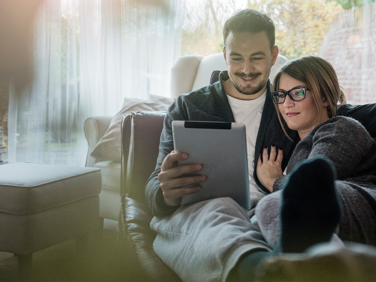 Father and daughter enjoying kitchen breakfast at laptop
