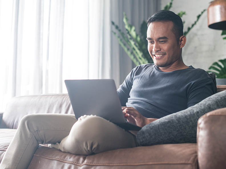 Man on lounge with laptop in casual home setting