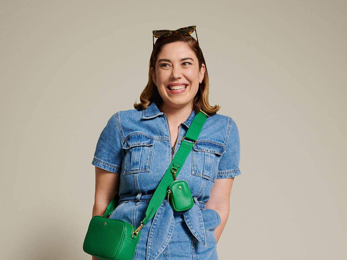 Casual young woman laughs while standing