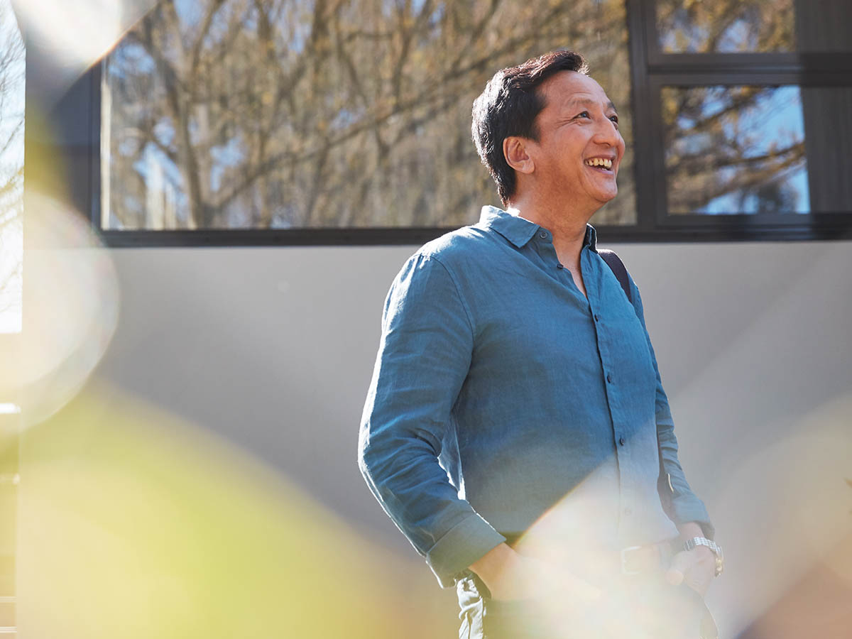 Middle aged Asian man standing outside his home on a sunny day. Macquarie customer - Chi