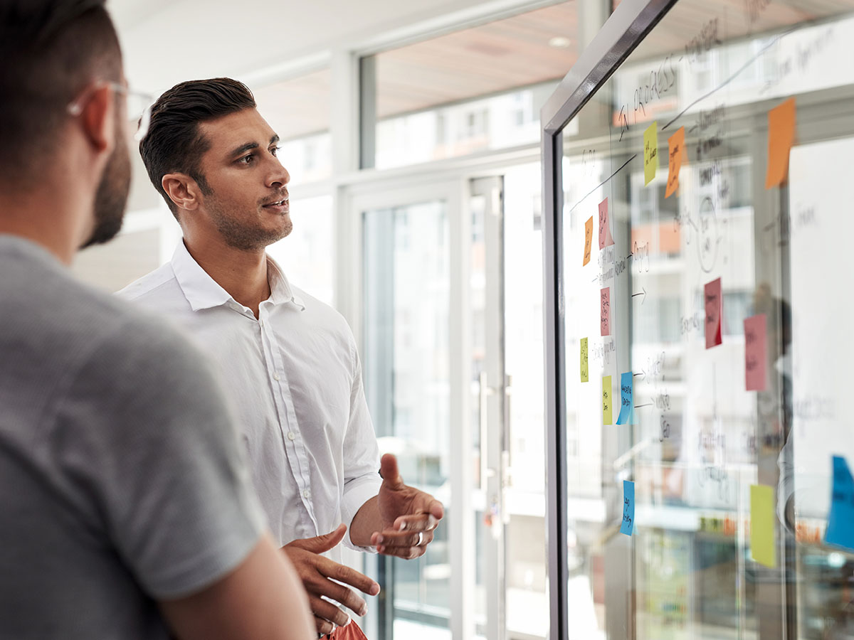 Industry expertise two men standing at kanban board
