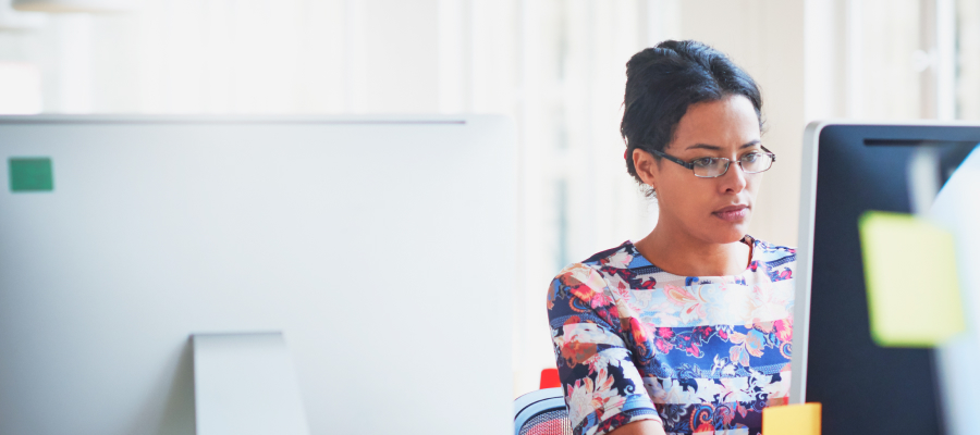 Image of a woman in an office looking at a computer