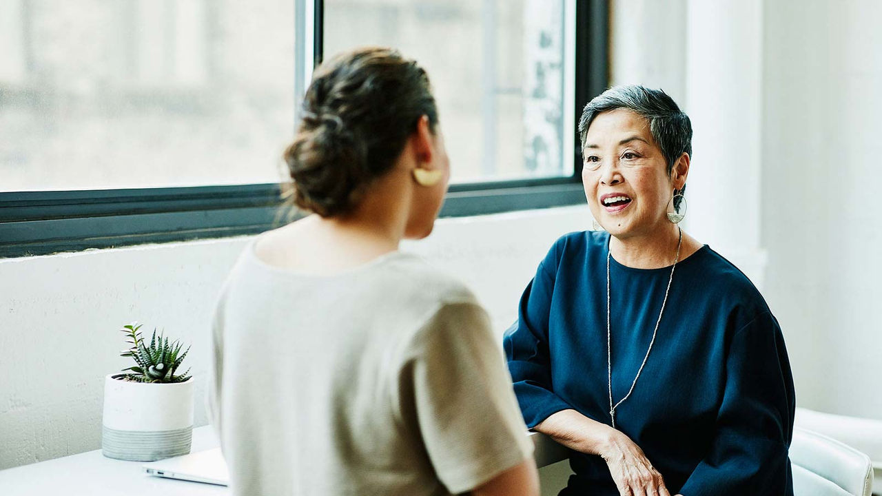 Two women talking in bright office