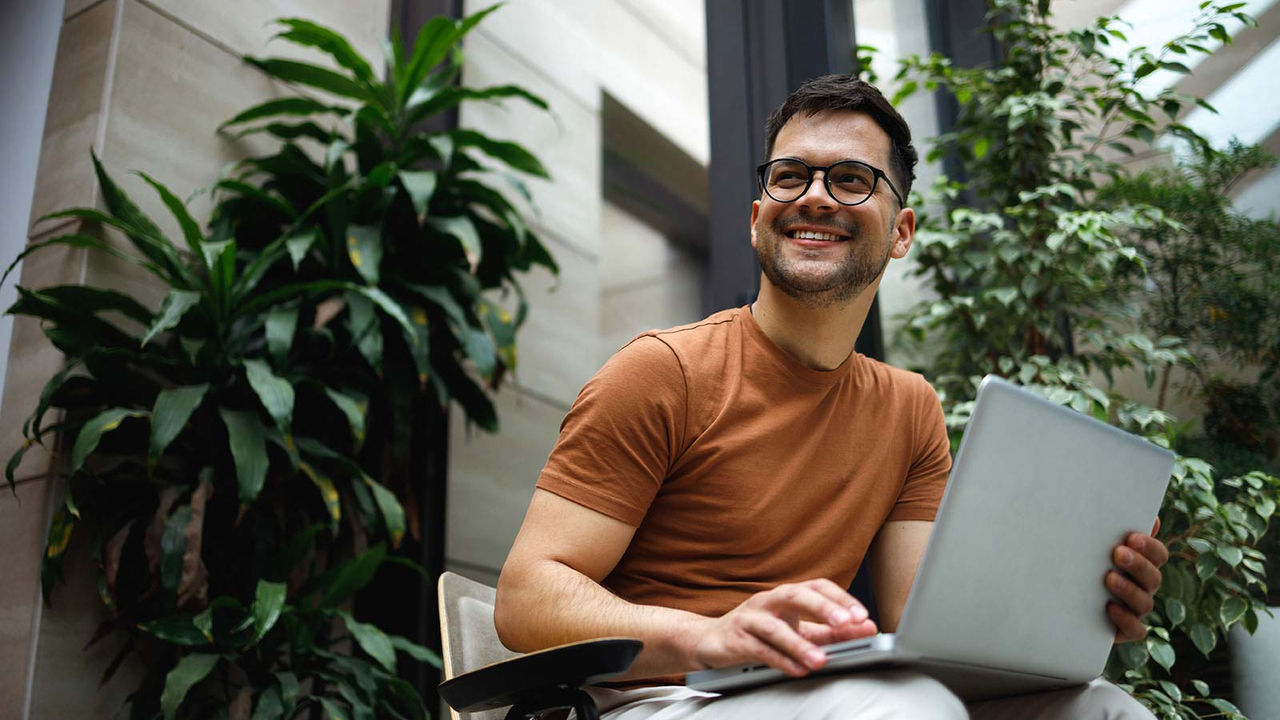 Casual man working on laptop outside