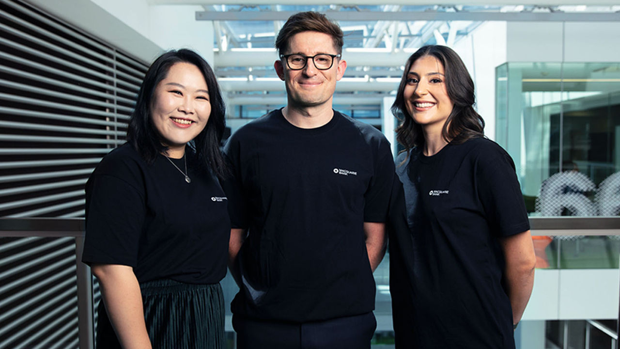 Group of three Macquarie staff home loan experts standing in office wearing tshirts