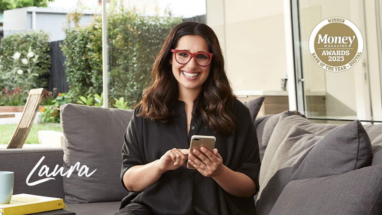 Laura sitting on couch with phone laughing
