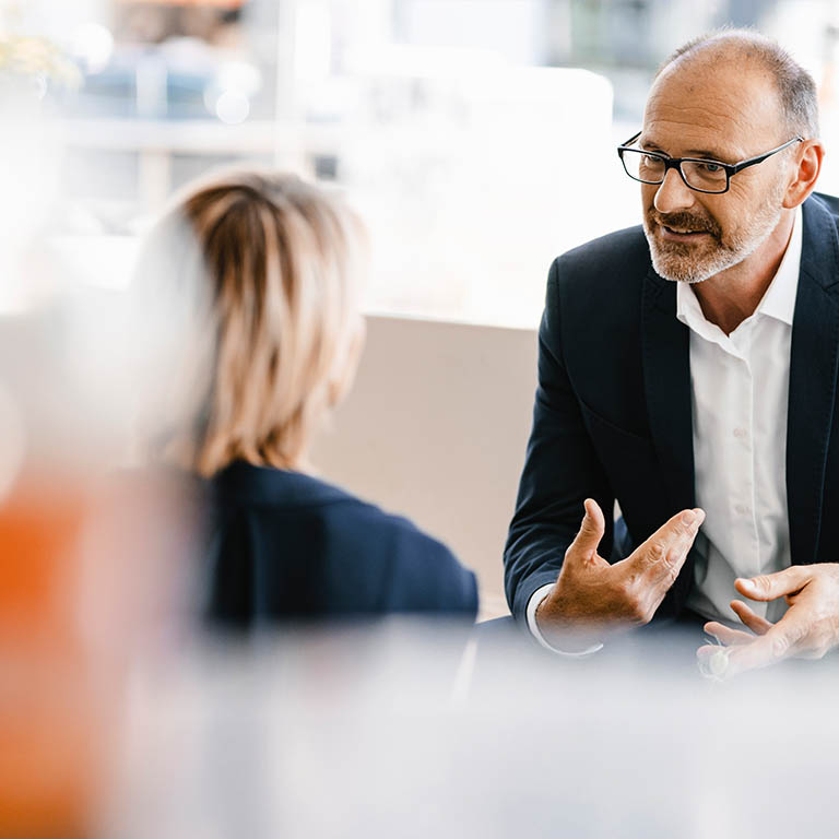 business man talking with woman in bright office
