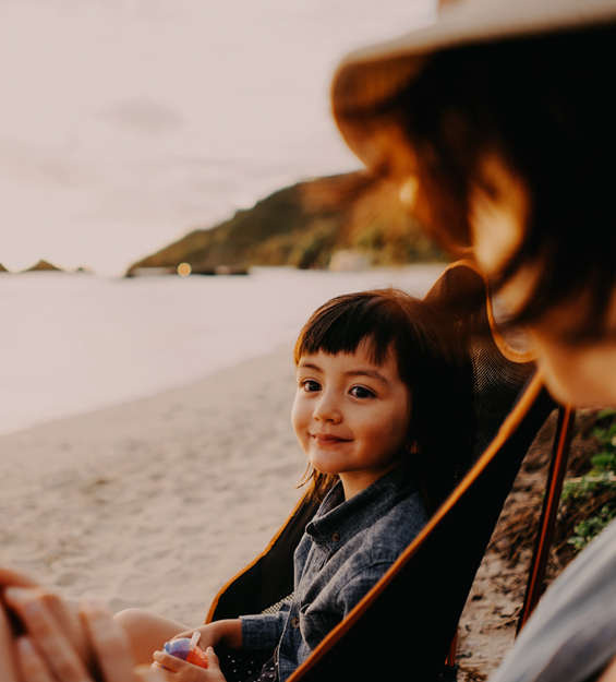 child sitting on chair at the beach