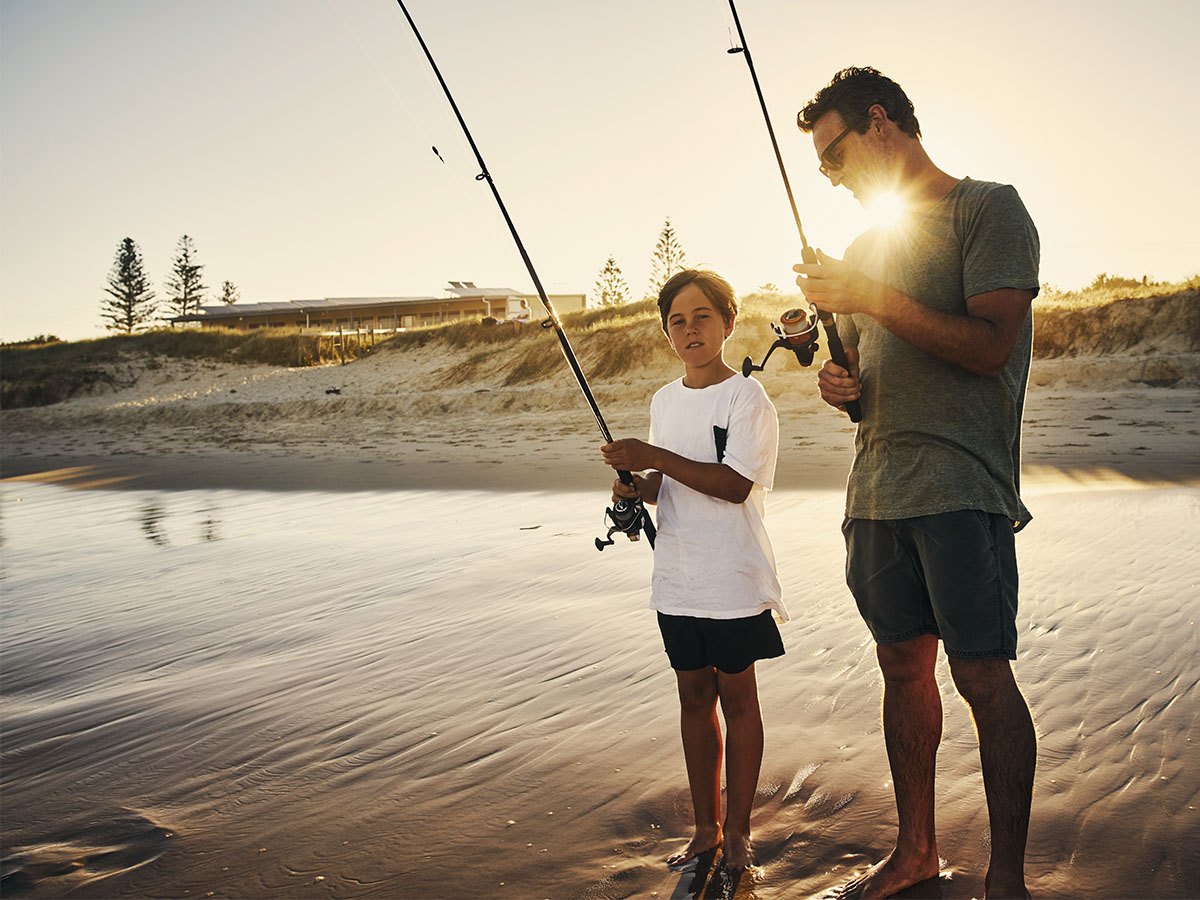 father and son fishing on beach