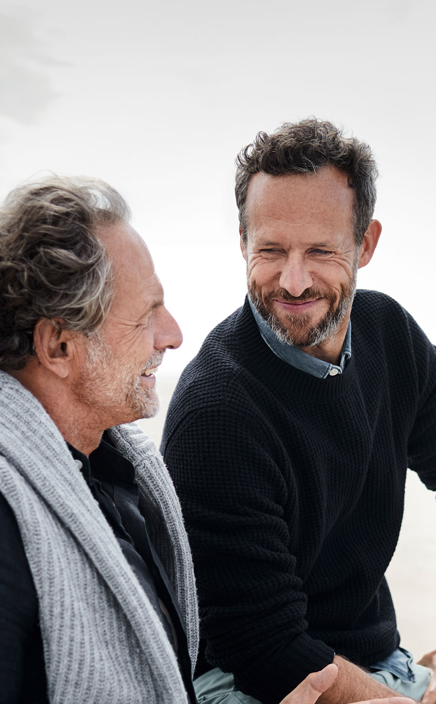 elder father and son talking at the beach