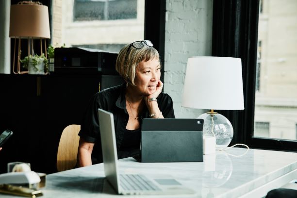 elegant lady at desk looking out window
