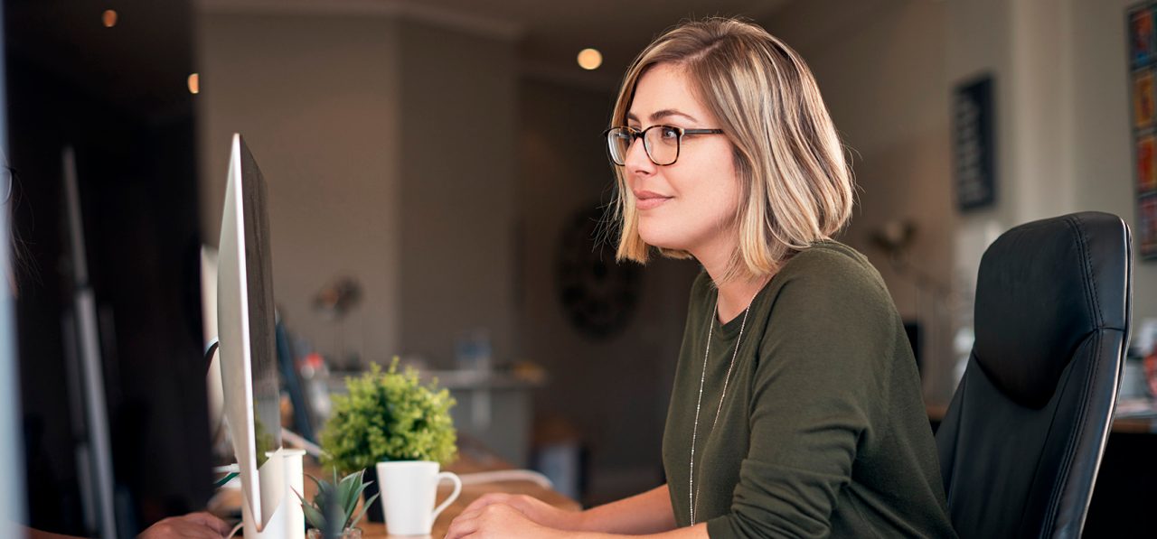 Woman smiling while sitting in front of computer